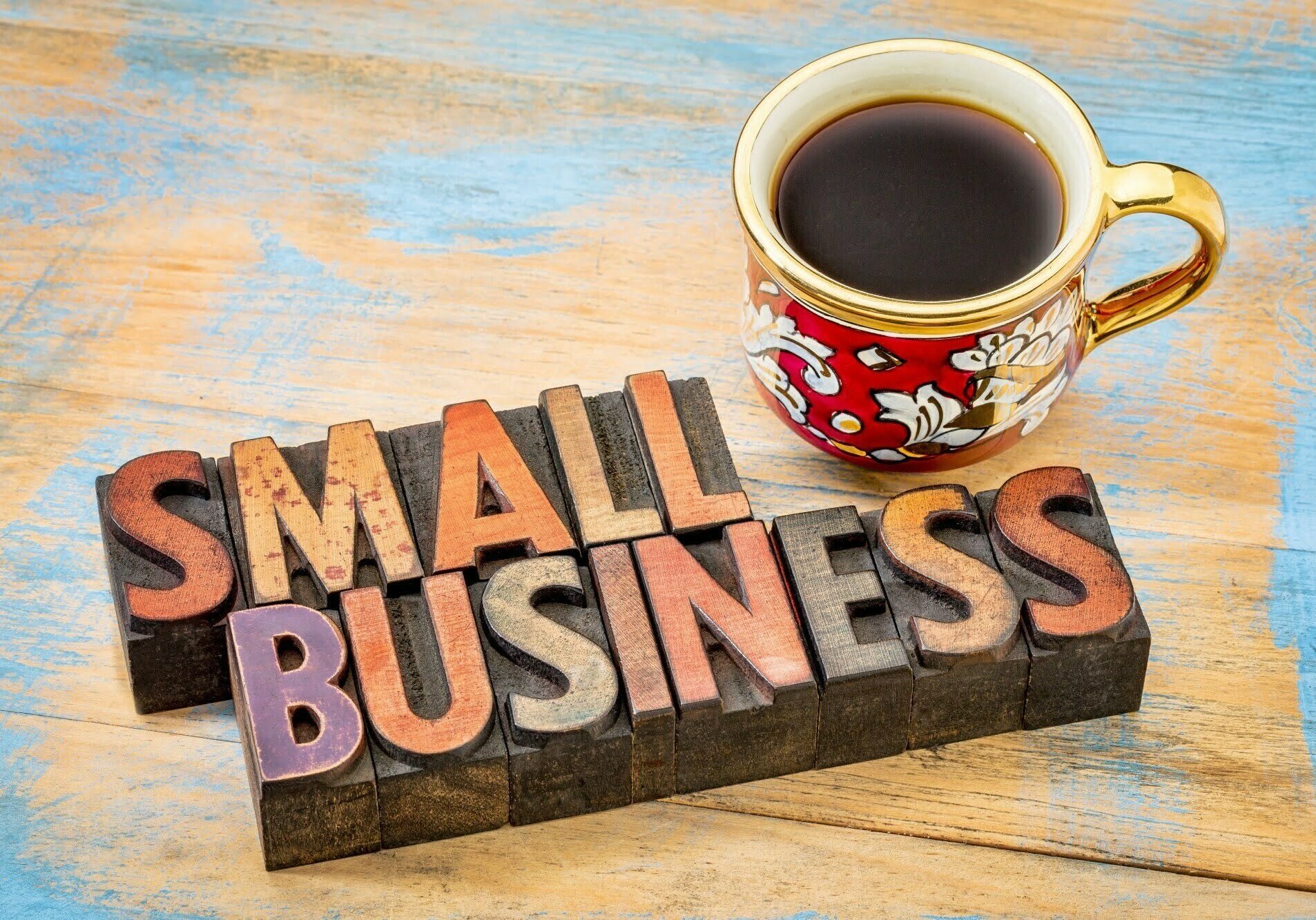 small business - text in vintage letterpress wood type printing blocks with a cup of coffee